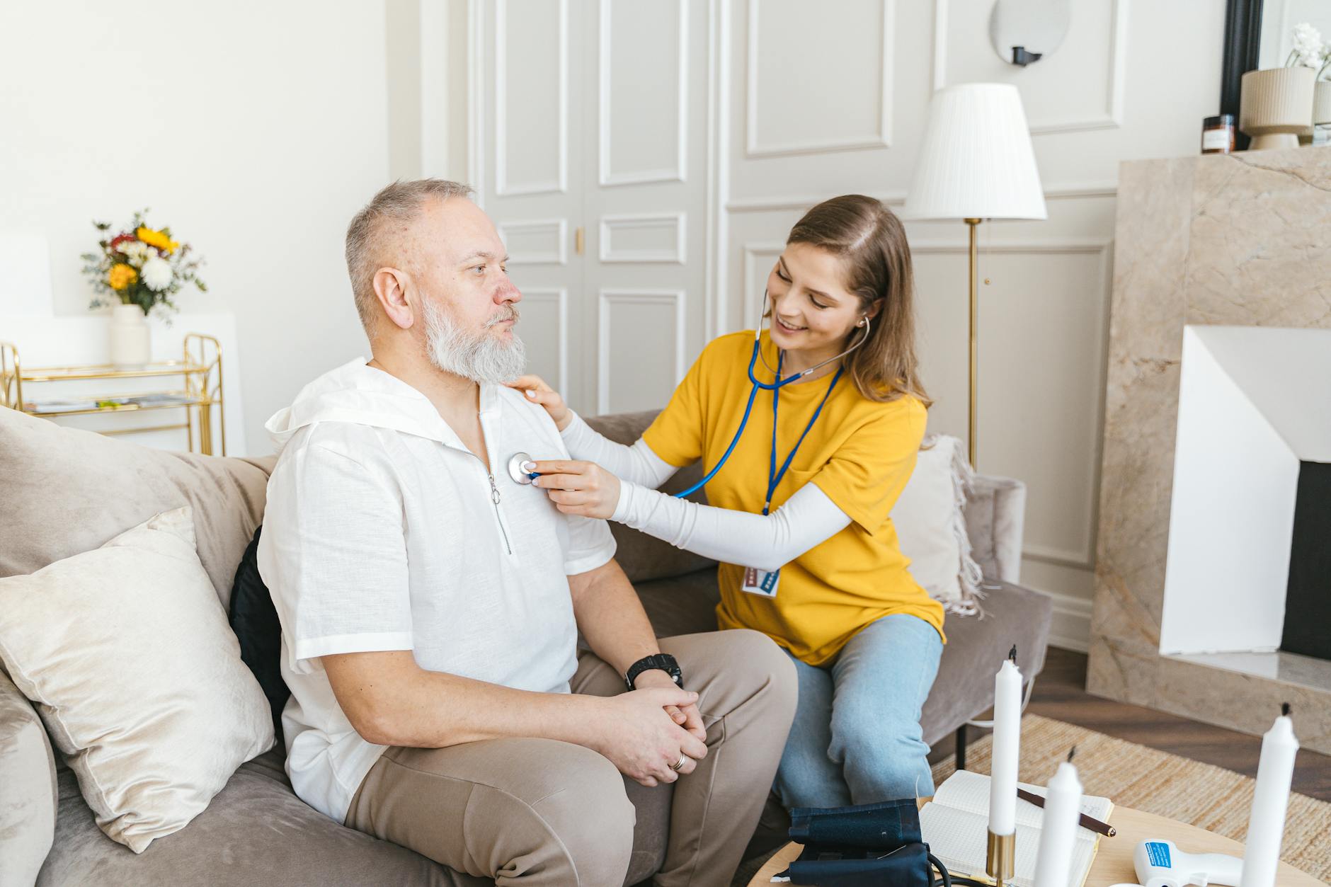 A care worker providing a health check to a person in their home